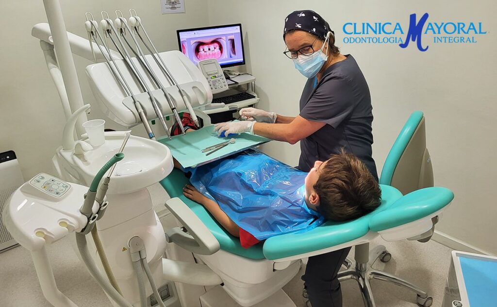 Odontólogo atendiendo a paciente de odontología para pacientes especiales con Síndrome de Down y a su madre en el centro dental Clínica Mayoral de Barcelona